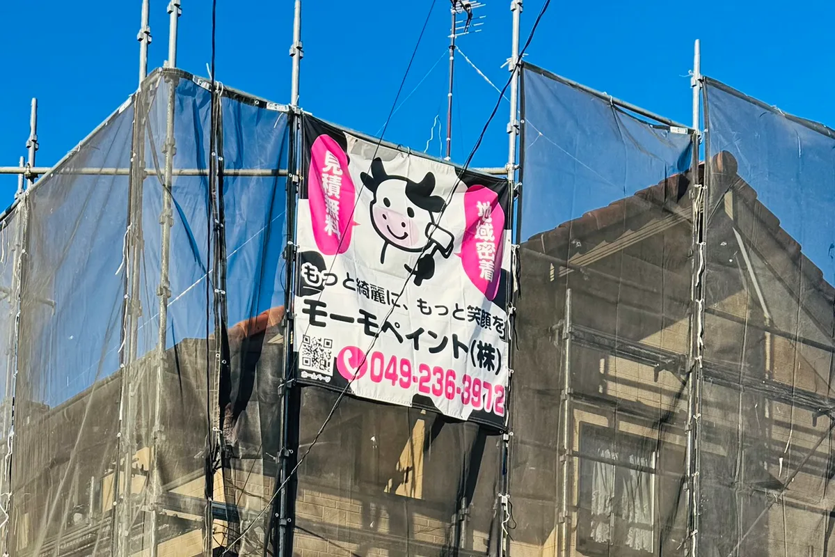 足場を組み、飛散防止のメッシュシートで覆った住宅