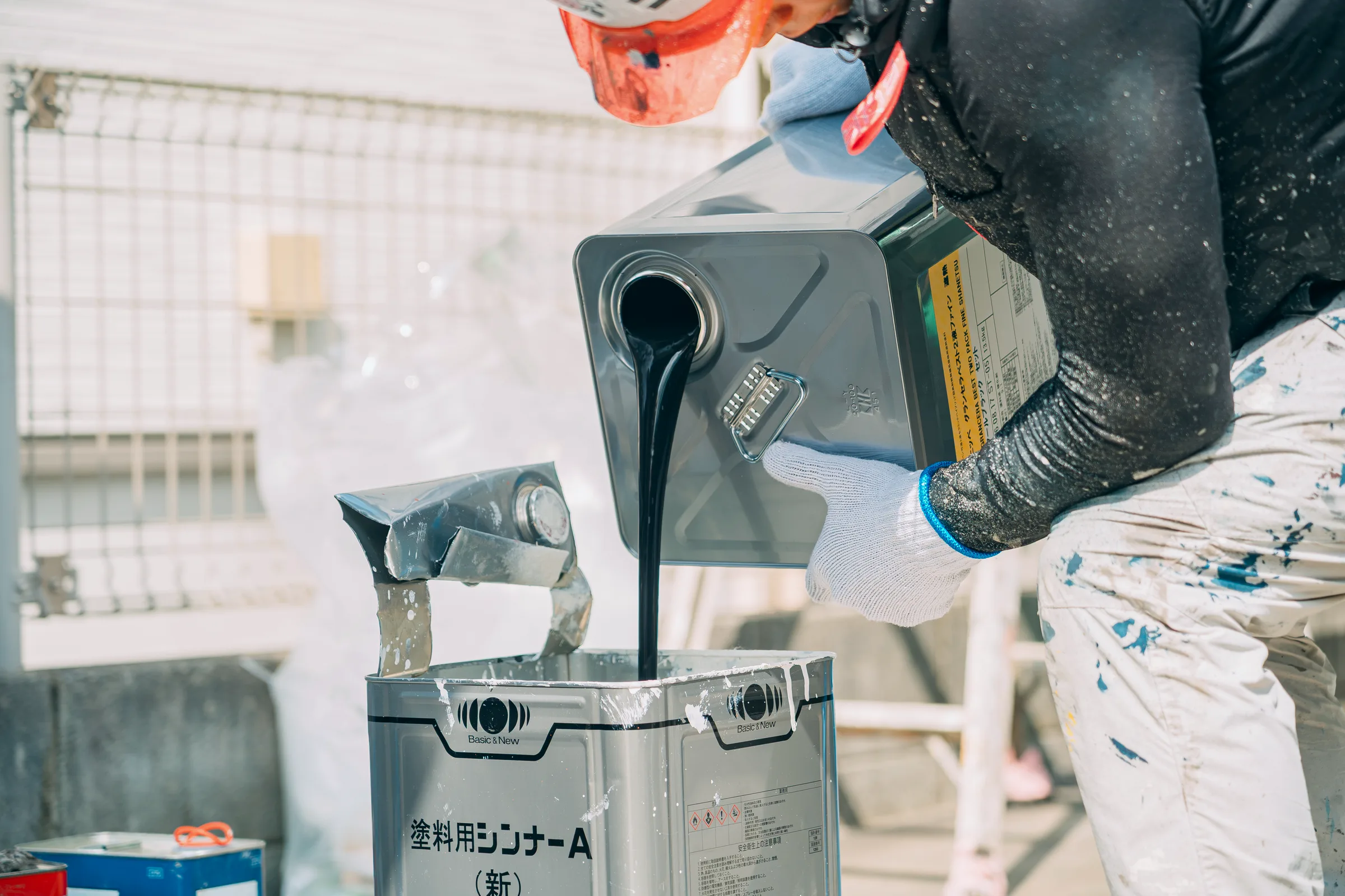 塗料用シンナーを缶に注ぐ手元