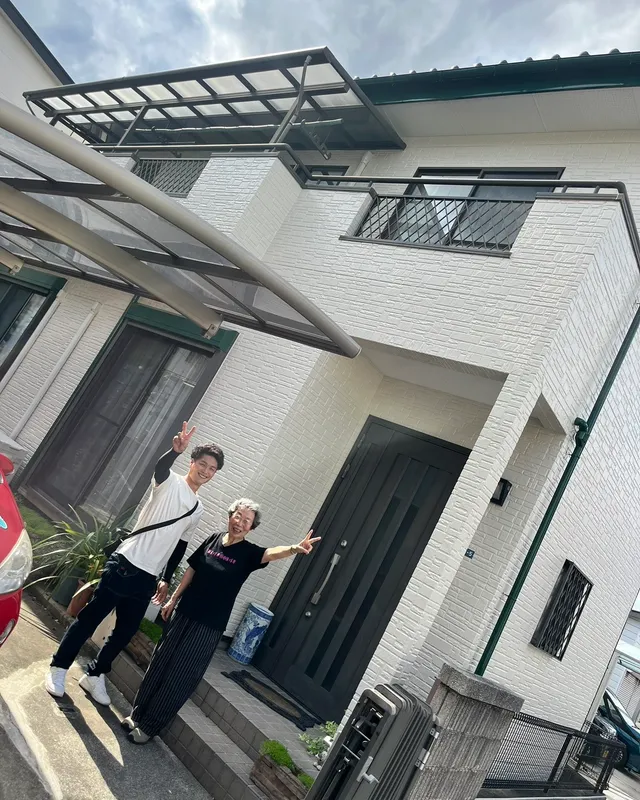 お住まいの前で手を振るお客様とスタッフ